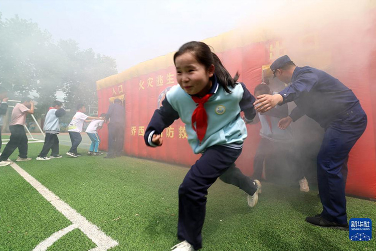 5月10日，消防员组织石家庄市桥西区城角街小学的学生们进行火灾逃生模拟演练。（新华社发 梁子栋摄）.jpg