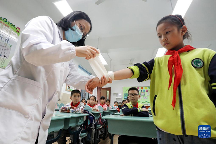 5月10日，在江苏省苏州市金阊实验小学校，校医给学生讲解包扎的方法。（新华社发 杭兴微摄）.jpg